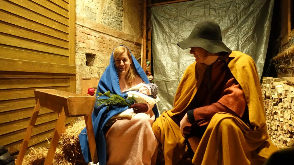 Maria und Josef sitzen mit ihrem Baby im Stall
