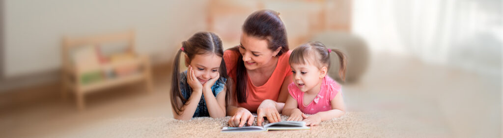 Mutter liest ihren zwei Kinder das Emmi-Osterbuch vor